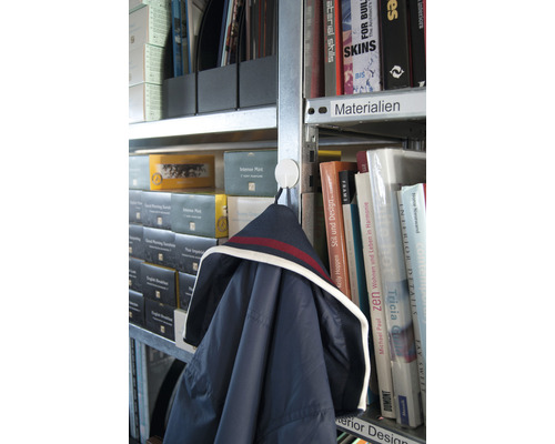 Jacke hängt an einem Haken in einem Bücherregal mit Büchern und Ordnern.