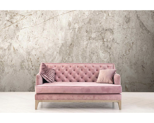 Rosa Sofa mit zwei Kissen vor einer Wandtapete mit Marmormuster.