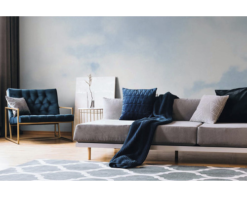 Wohnzimmer mit gemusterter Tapete, Sofa, Sessel und Teppich