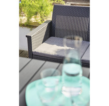 Gartenlounge mit grauen Auflagen und Tisch mit Gläsern