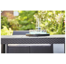 Nahaufnahme eines Gartentisches mit Rattanmuster und einer Wasserflasche mit Gläsern auf einem Tablett
