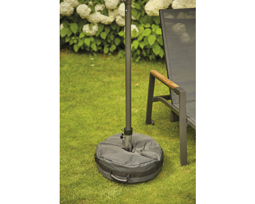 Sonnenschirmständer mit Sandsackfuß auf einer Rasenfläche.