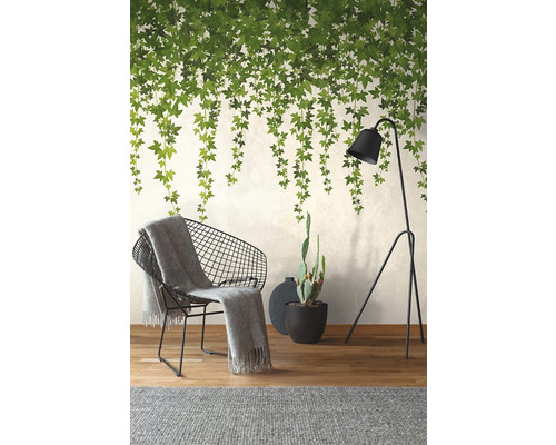 Dekoratives Wohnzimmer mit Tapete mit Pflanzenmotiven, Sessel, Stehlampe und Zimmerpflanze