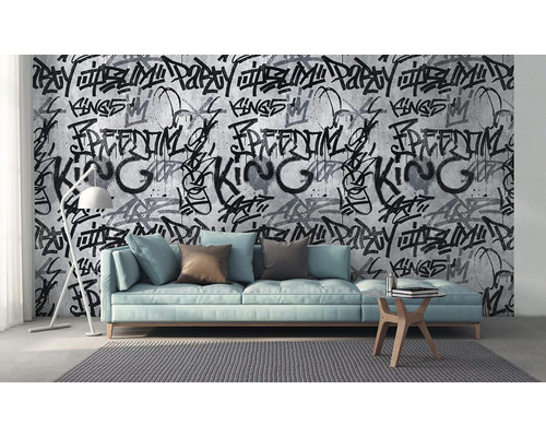 Wohnzimmer mit Sofa, Lampe und Tapete mit Graffiti-Motiv