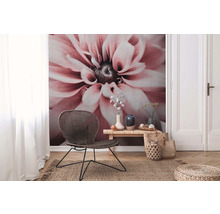 Wohnraum mit Blumentapete, Rattansessel, Holztisch und Jute Teppich für eine natürliche Atmosphäre.