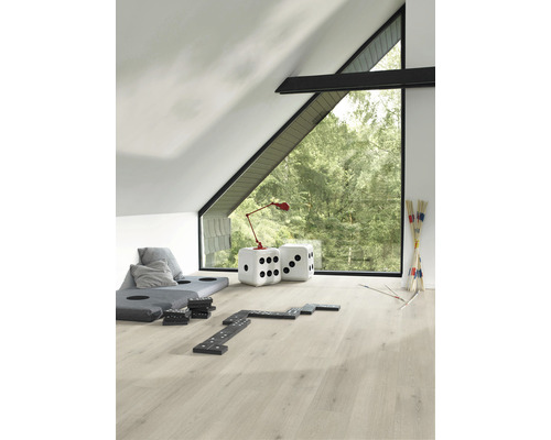 Heller Dachbodenraum mit Laminatboden, großem Fenster und Dekorationsgegenständen