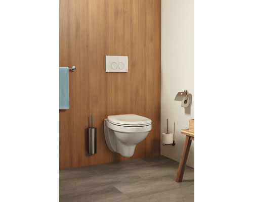 Wandhängendes WC mit Betätigungsplatte, Toilettenbürste und Handtuchhalter in einem Badezimmer.