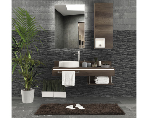 Badezimmer mit Waschtisch, Spiegel, Handtüchern, Teppich und Zimmerpflanzen