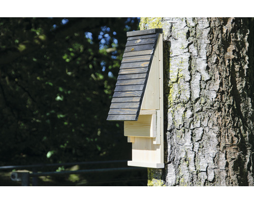 Holz-Fledermaushaus an einem Baumstamm befestigt