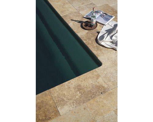 Pool mit Travertinplatten, Wasserflasche, Zeitschrift, Sonnenbrille und Handtuch