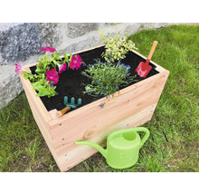 Hochbeet aus Holz mit Blumen, Gießkanne und Gartengeräten im Garten