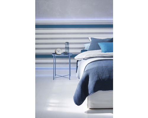 Schlafzimmer mit Bett, Nachttisch und dekorativer Wandgestaltung