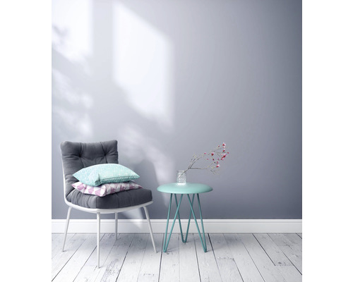 Szene mit einem Stuhl mit Kissen und einem Beistelltisch mit Blumenvase vor einer Wand