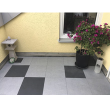 Terrasse mit Pflastersteinen, Pflanze und Dekorationen.
