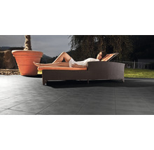 Terrasse mit Terrassenplatten, Liege und Pflanzkübel im Außenbereich