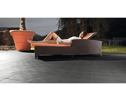 Terrasse mit Terrassenplatten, Liege und Pflanzkübel im Außenbereich