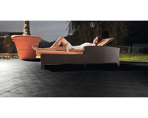 Terrasse mit Bodenfliesen und Frau auf einer Sonnenliege