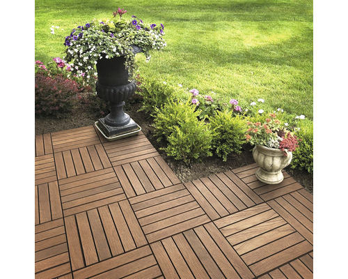 Verlegte Terrassenfliesen im Garten mit Blumen in Pflanzgefäßen.