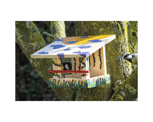 Bemaltes Vogelhaus aus Holz mit auf einem Baum sitzender Meise