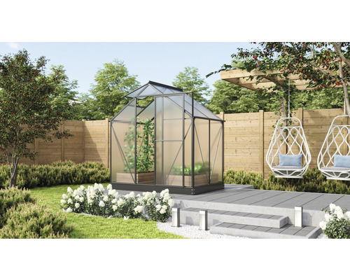 Gewächshaus im Garten mit Pflanzen und Sitzgelegenheiten.