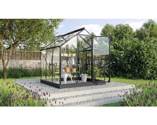 Gewächshaus mit Regalen und geöffneter Tür im Garten.