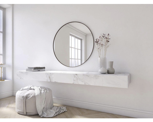 Szene mit einem runden Spiegel, einem Wandregal mit Marmoroptik, Vasen, Büchern und einem Hocker.