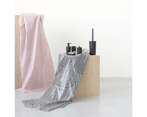 Badezimmer-Szene mit Accessoires wie Seifenspender, Becher, Seifenschale und WC-Garnitur sowie Textilien mit grafischen Mustern