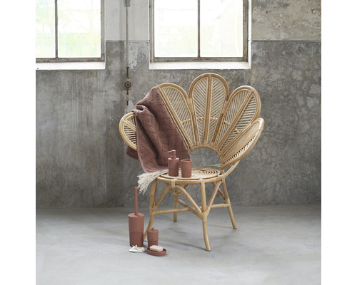 Badezimmerinszenierung mit Rattansessel, Handtuch und Badaccessoires