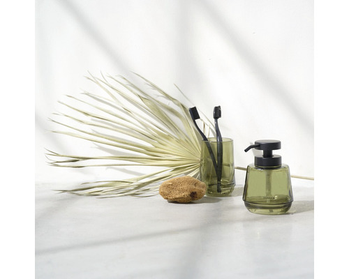 Badezimmerstillleben mit Zahnputzbecher, Seifenspender, Badeschwamm und Dekoration