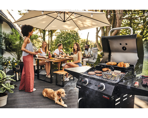Grillszene mit Menschen, Gartentisch, Sonnenschirm und Hund