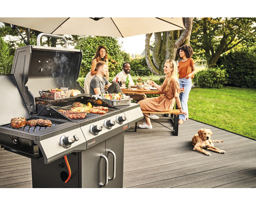 Szene mit Grillparty im Garten, Grill mit Speisen und Menschen an einem Tisch