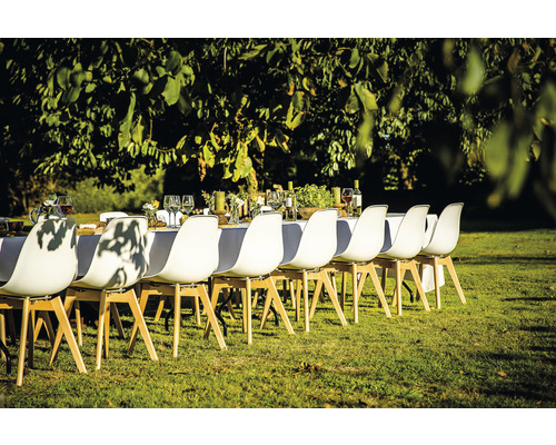 Szene einer gedeckten Tafel im Freien mit weißen Stühlen auf Rasenfläche