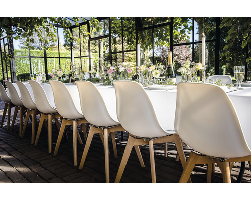 Festlich gedeckter Tisch mit Stühlen für eine Veranstaltung im Freien.