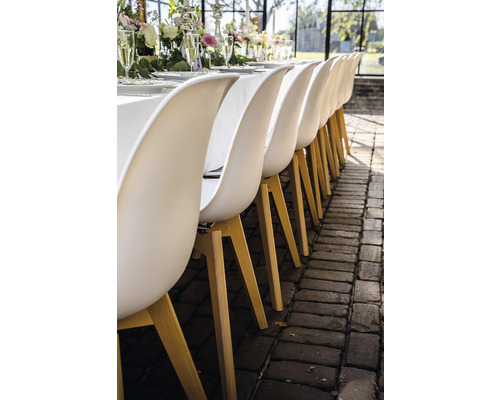 Reihe von Esszimmerstühlen mit Holzbeinen an einem gedeckten Tisch