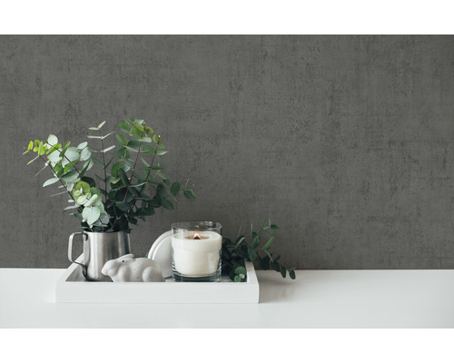 Dekorative Szene mit Kerze, Pflanze und Dekofigur auf einem Tablett vor einer Wand.