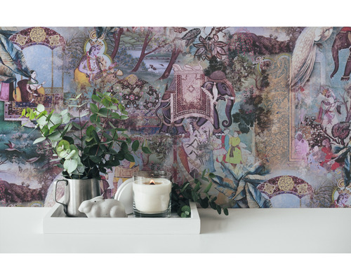 Dekorative Szene mit gemusterten Tapeten, Kerze, Hasenfigur und Eukalyptus in einem Krug