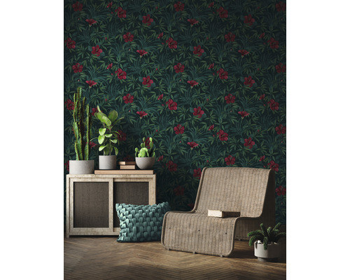 Wohnzimmer mit Hibiskus Tapete, Rattansessel und Zimmerpflanzen auf einem Schrank