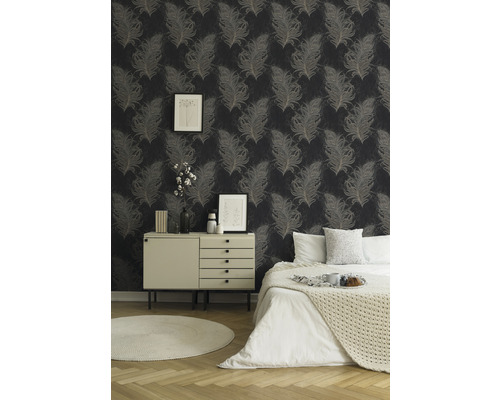 Schlafzimmer mit Feder-Tapete, Kommode und Bett.