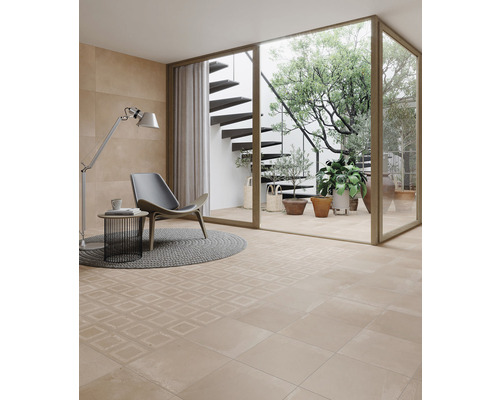 Heller Raum mit Bodenfliesen, Sessel und Blick in einen Garten mit Treppe