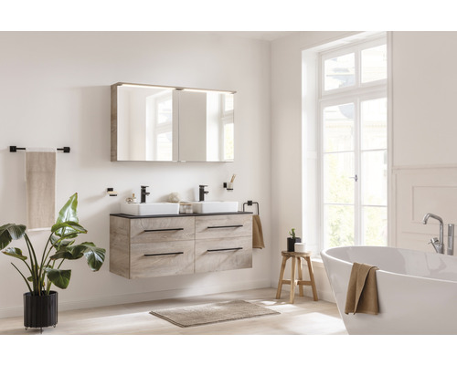 Helles Badezimmer mit Doppelwaschtisch, Spiegel, Badewanne und Zimmerpflanze