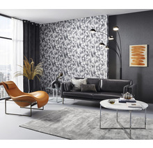 Wohnzimmer mit Sofa, Sessel, Stehlampe, Teppich und gemusterter Tapete