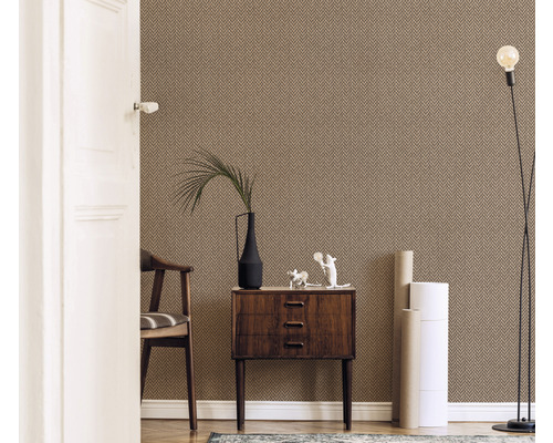 Wohnraum mit gemusterter Tapete, Kommode, Stuhl, Stehlampe und Dekorationsgegenständen.