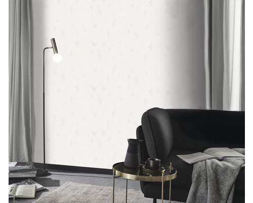 Wohnzimmer mit Stehlampe, Sessel, Beistelltisch und weißer Tapete