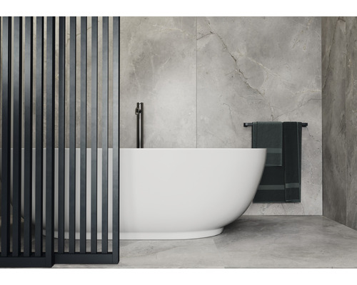 Badezimmer mit freistehender Badewanne, Raumteiler und Handtüchern