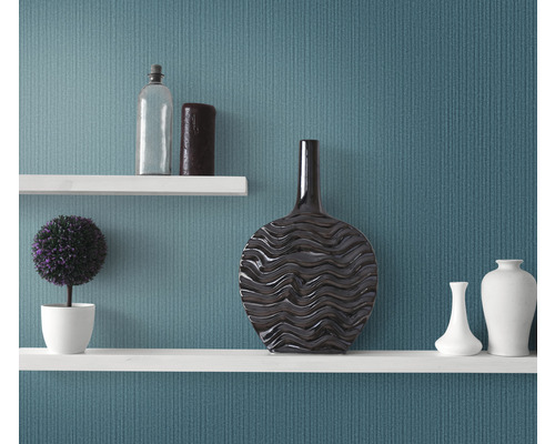 Dekorative Regale mit Vasen, einer Pflanze und einer Flasche vor einer Wand