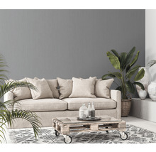 Wohnzimmer mit Sofa, Couchtisch aus Paletten, Zimmerpflanzen und grauer Wandtapete
