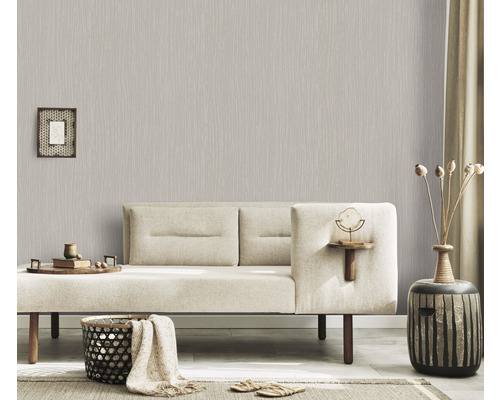 Wohnzimmer mit hellgrauer Vliestapete mit linearem Muster, Sofa und Dekoartikeln für ein gemütliches Ambiente.