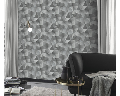 Wohnzimmer mit geometrischer Tapete, Stehlampe und Sofa.