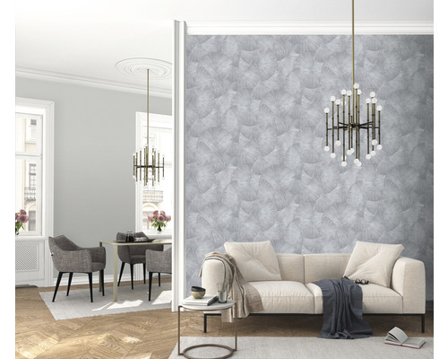 Heller Wohnraum mit Sofa, Tisch, Stühlen, Lampe und gemusterter Tapete