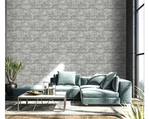 Wohnzimmer mit grauer Backstein-Tapete, Sofa und Pflanze